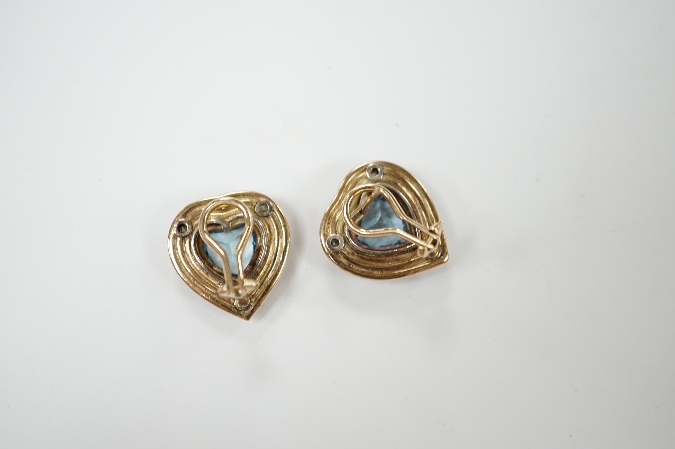 A pair of yellow metal, single stone heart shaped aquamarine and three stone diamond chip set earrings, 18mm, gross weight 7.5 grams. Condition - fair